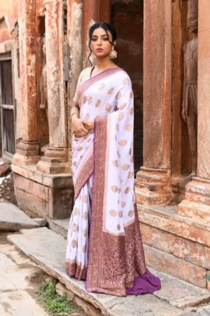 Off-white Banarasi silk saree handwoven with gold zari buta motifs and purple border from Golden Muslin by Naaritva Banaras
