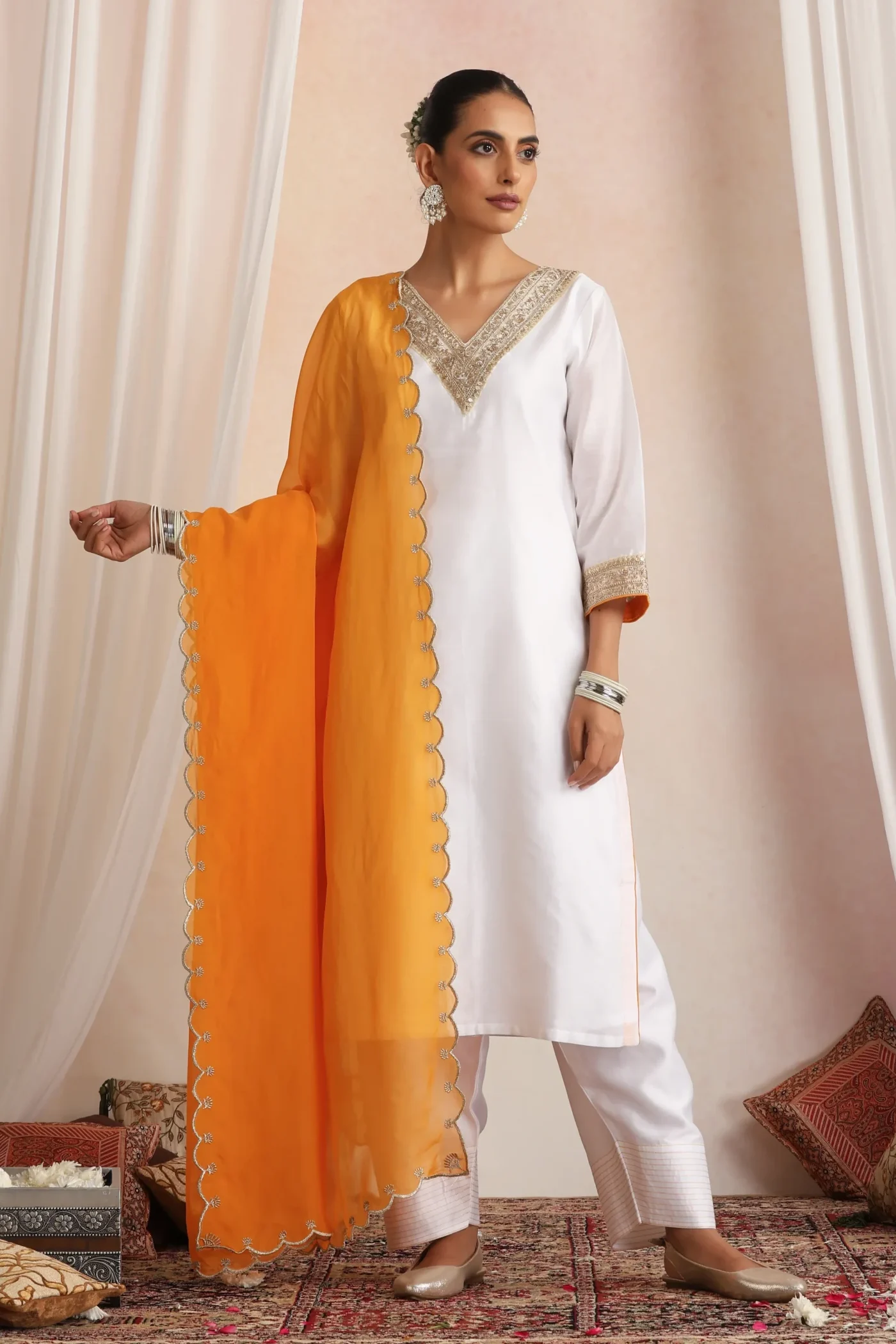 White ethnic kurta set with vibrant orange dupatta from Golden Muslin By Suikala