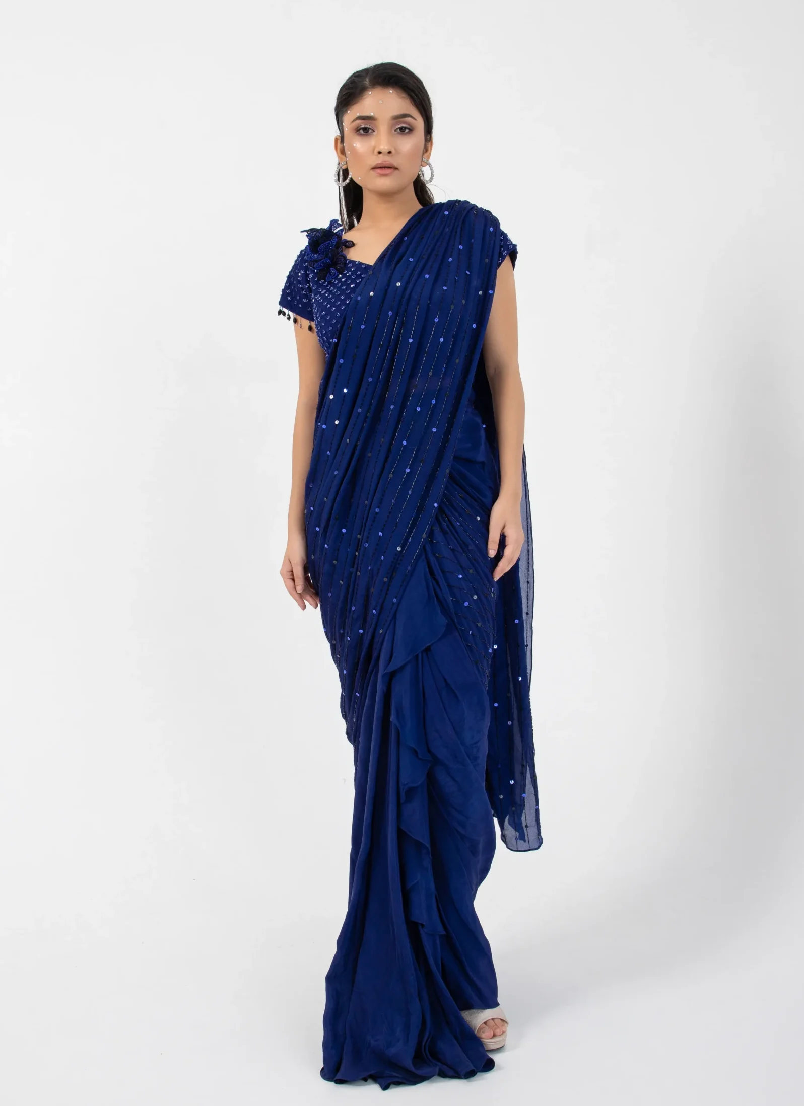 Model wearing midnight navy golden muslin embellished saree with fully beaded blouse and dangling sleeve trims