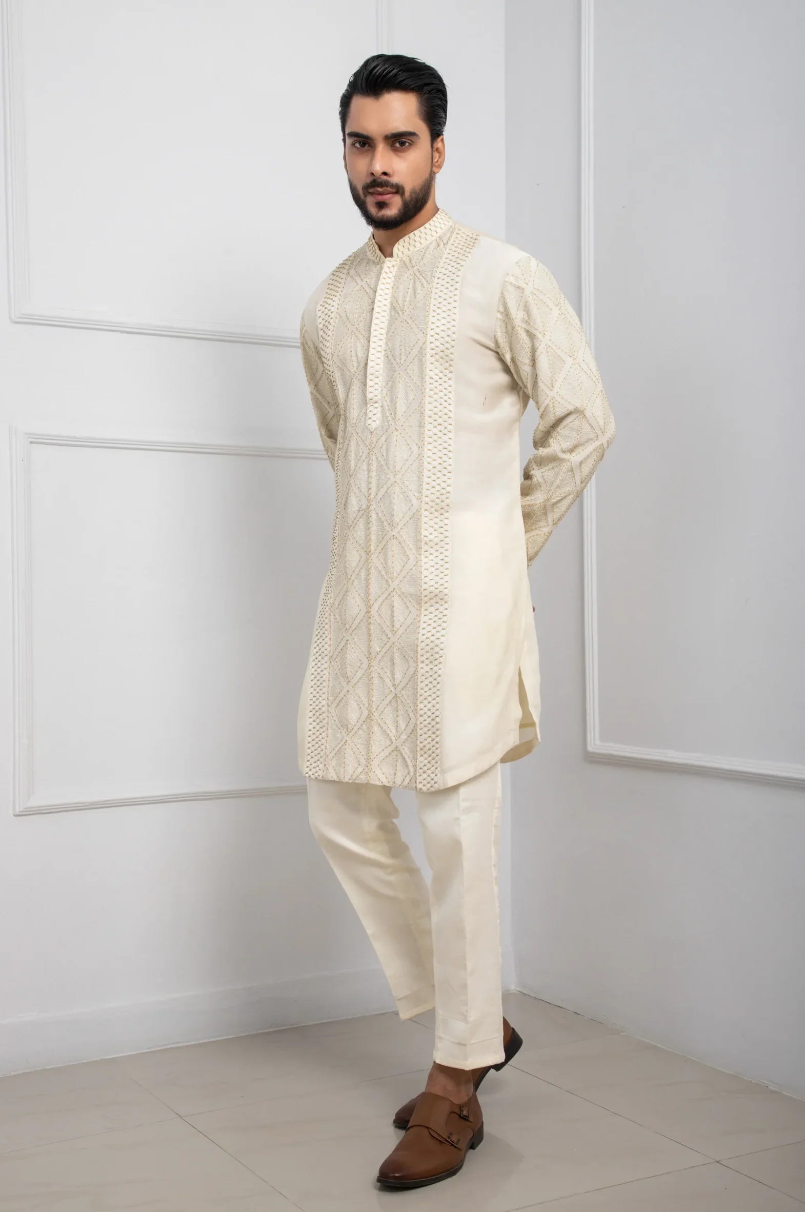 Model wearing ivory gilded golden muslin kurta set with geometric embroidery and straight trousers