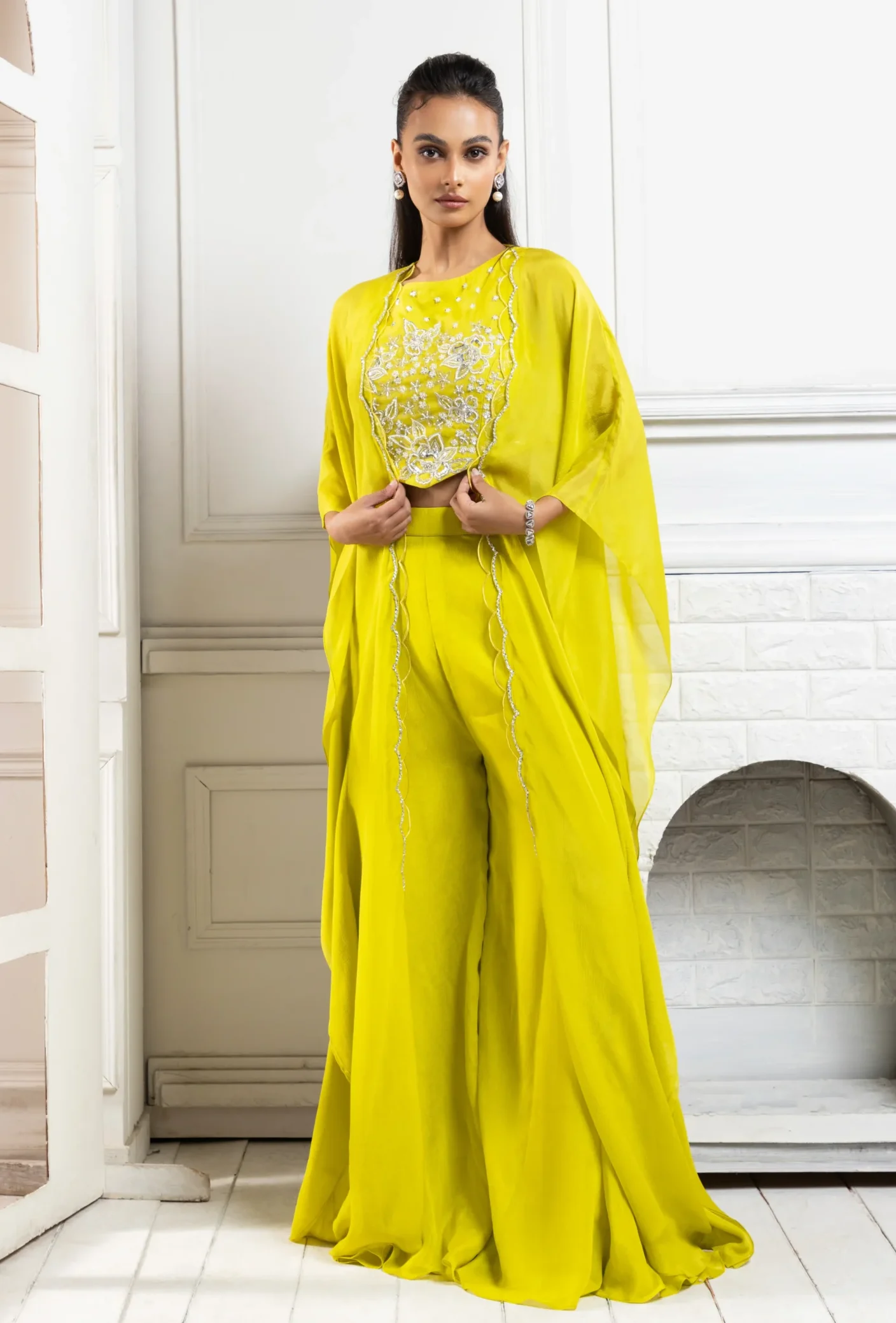 Model wearing chartreuse golden muslin cape palazzo set with embroidered cape and wide-leg palazzo pants