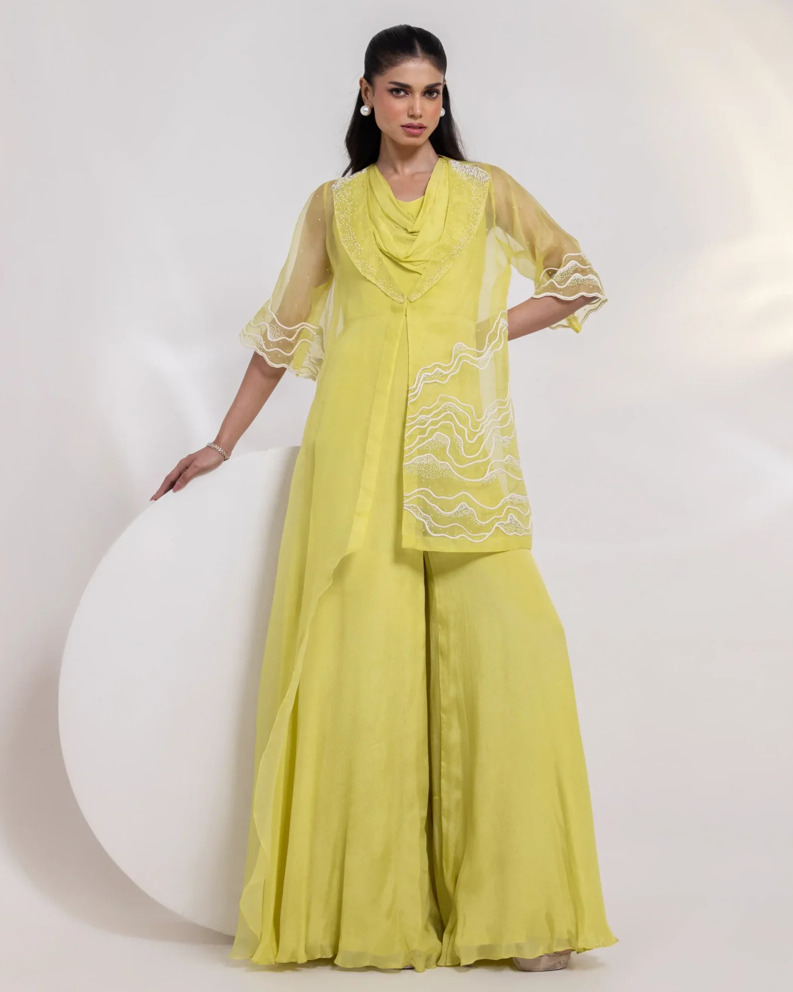 Vibrant Yellow Jumpsuit Cordset with Asymmetrical Sheer Jacket and Embellished Bell Sleeves from Golden Muslin By Anuj Agarwal