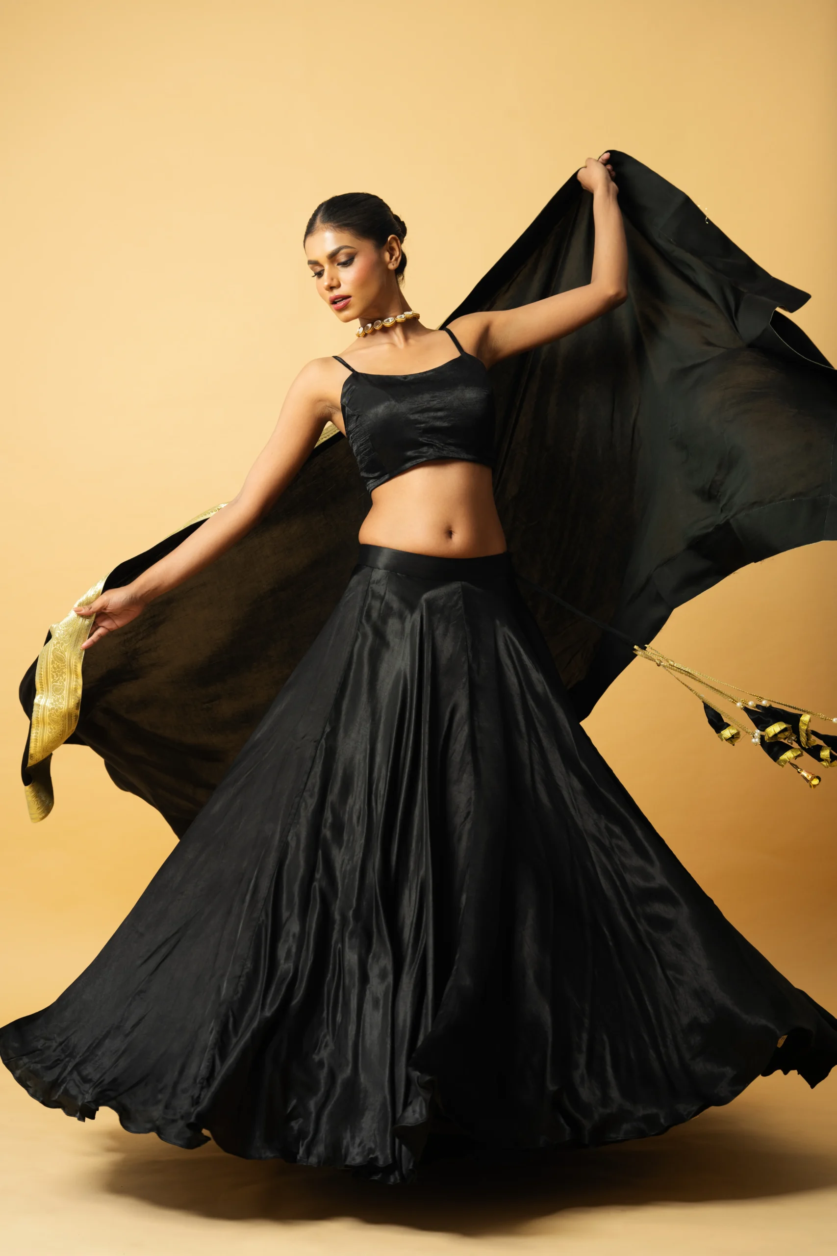 Black Modal Satin Lehenga with sleeveless blouse and golden lace dupatta from Golden Muslin By Quench A Thirst