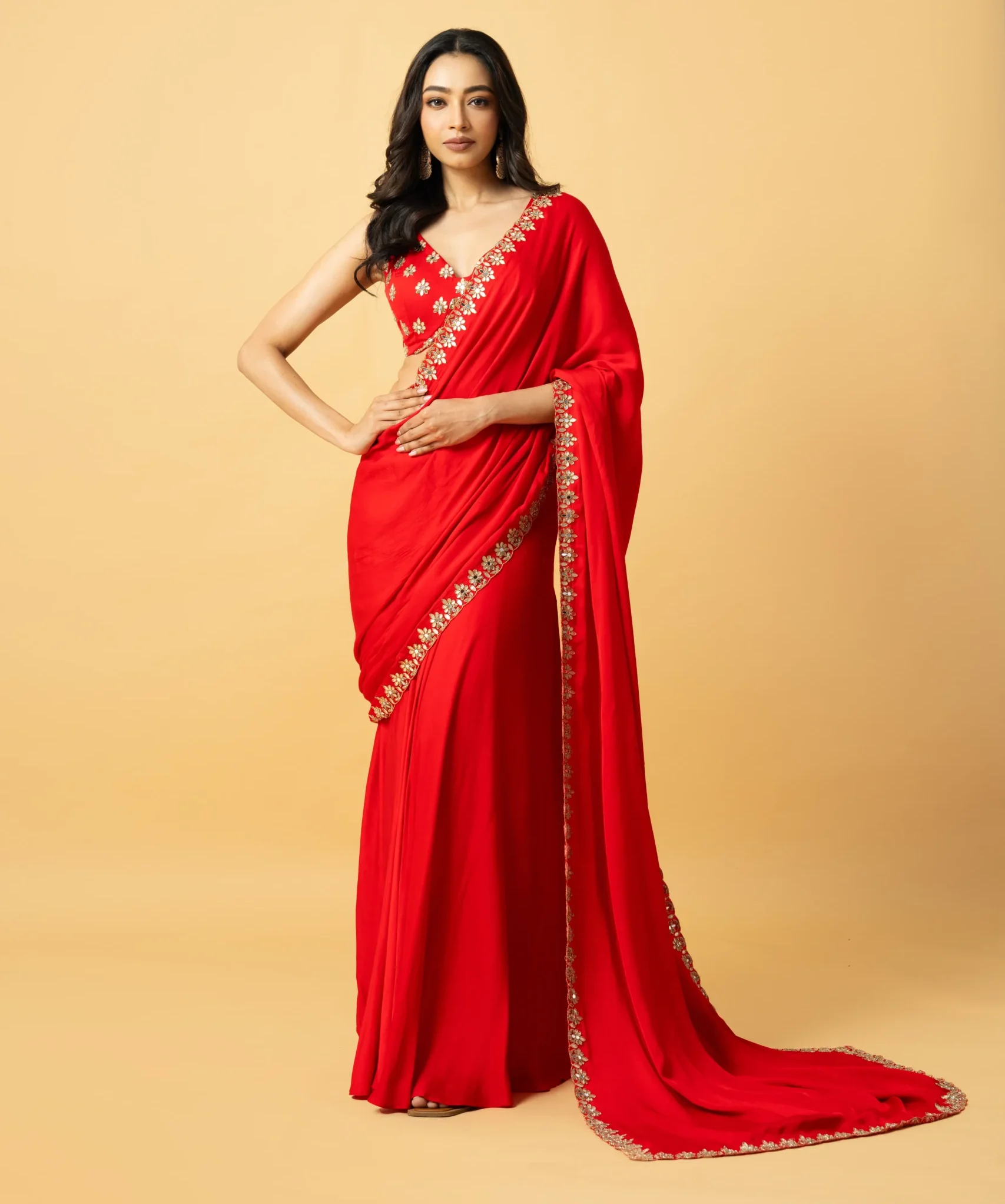 Red Modal Satin Pre-Draped Saree with hand-embroidered sleeveless blouse featuring mirror work and zari from Golden Muslin By Quench A Thirst